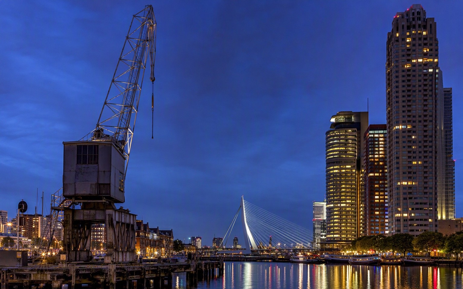 Rijnhaven met kraan en Rotterdamse skyline in avondlicht
